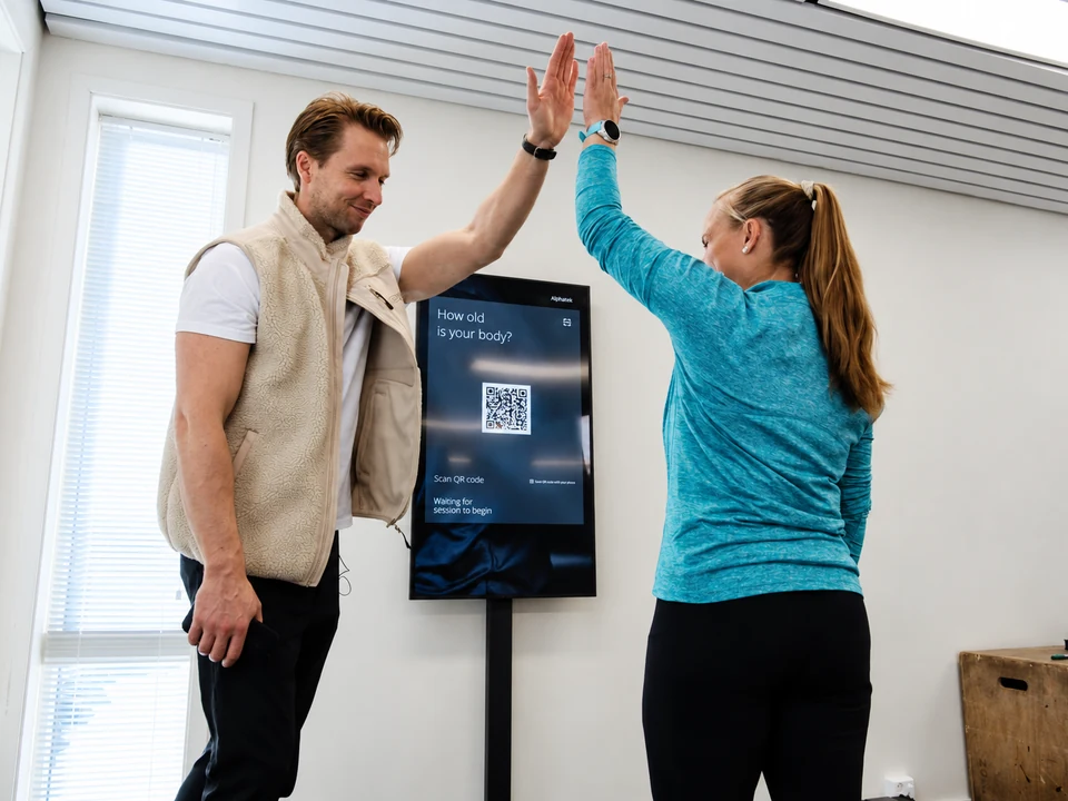 A trainer and member give each other a high-five.