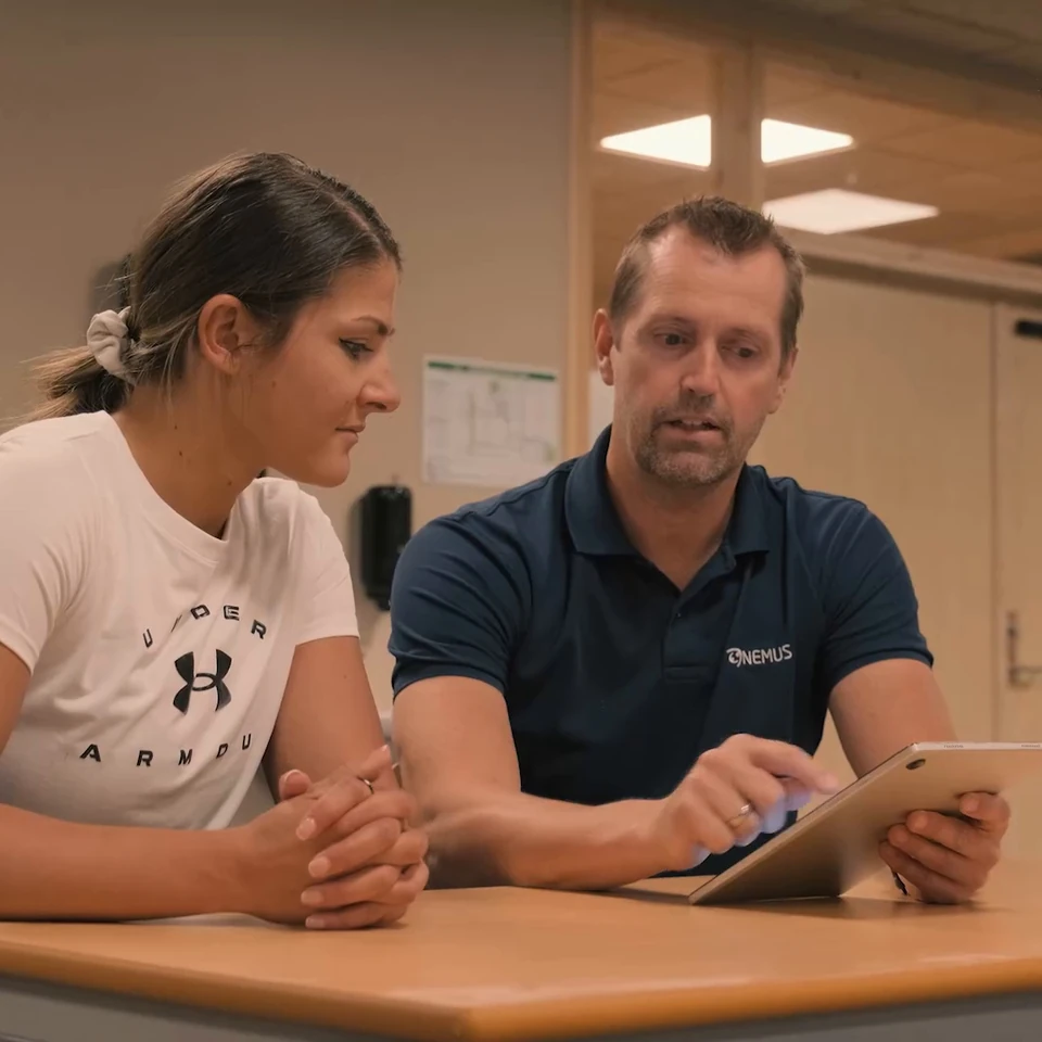 An athlete and a practitioner review a tablet together.