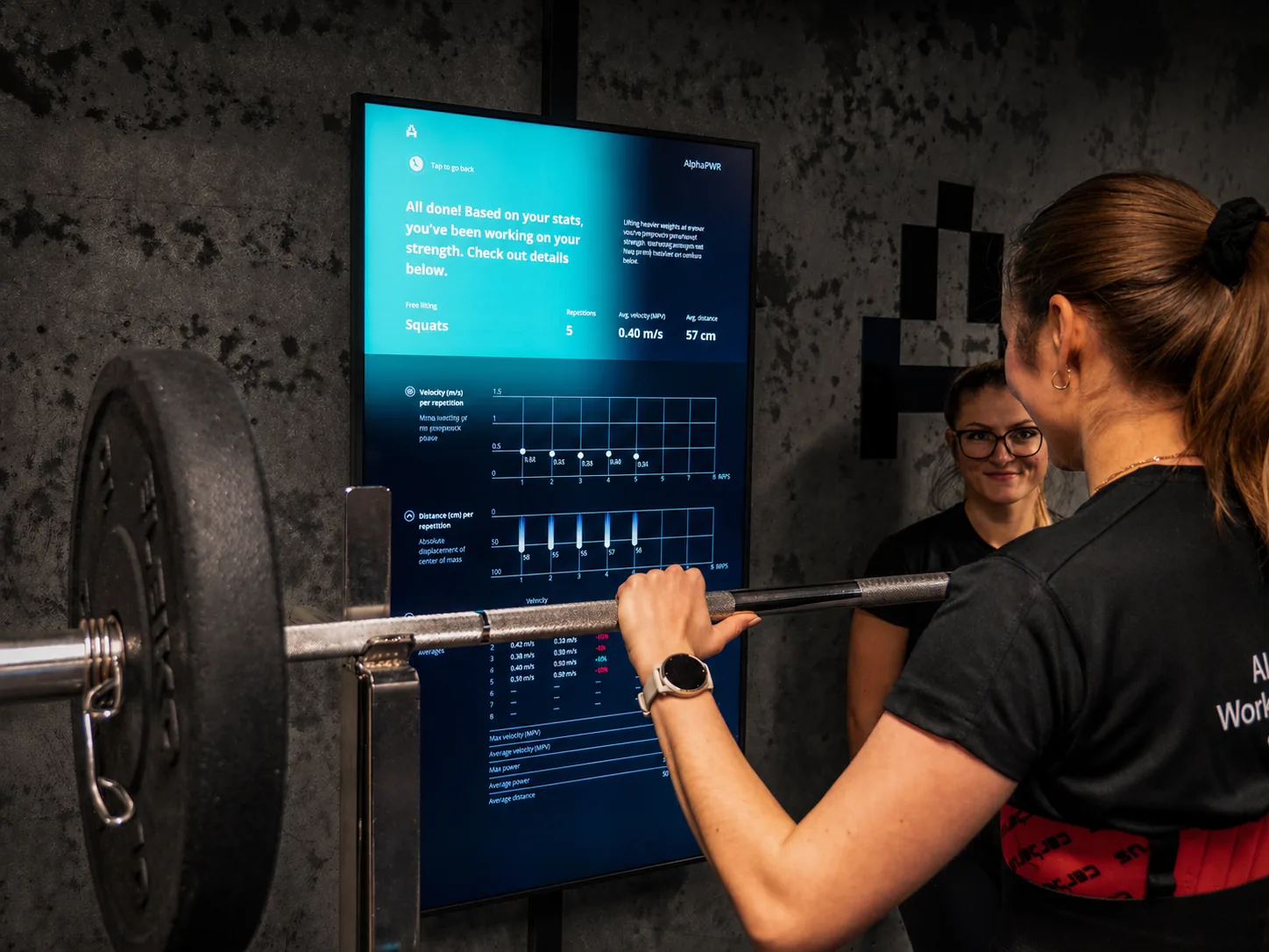 A professional guides a participant while Alphatek shows live feedback.